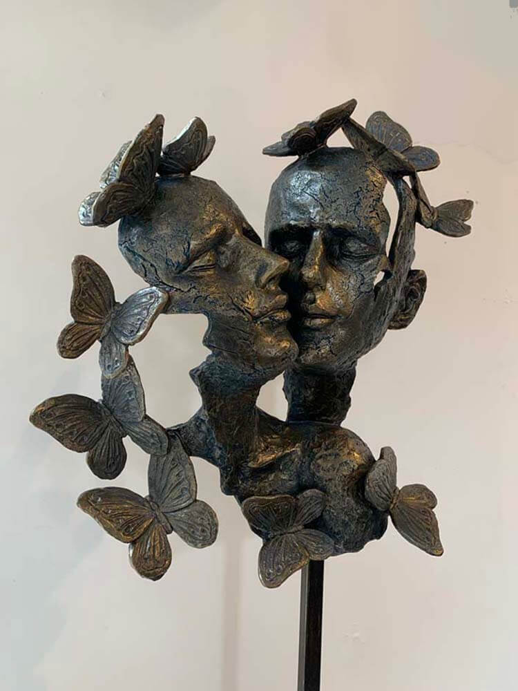 Bronze sculpture of two faces with butterflies by The Dutch Hospital