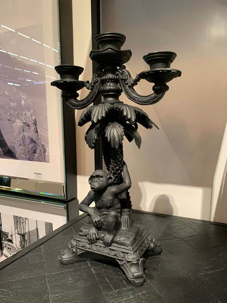 Decorative candle holders featuring a black monkey holding a palm tree 