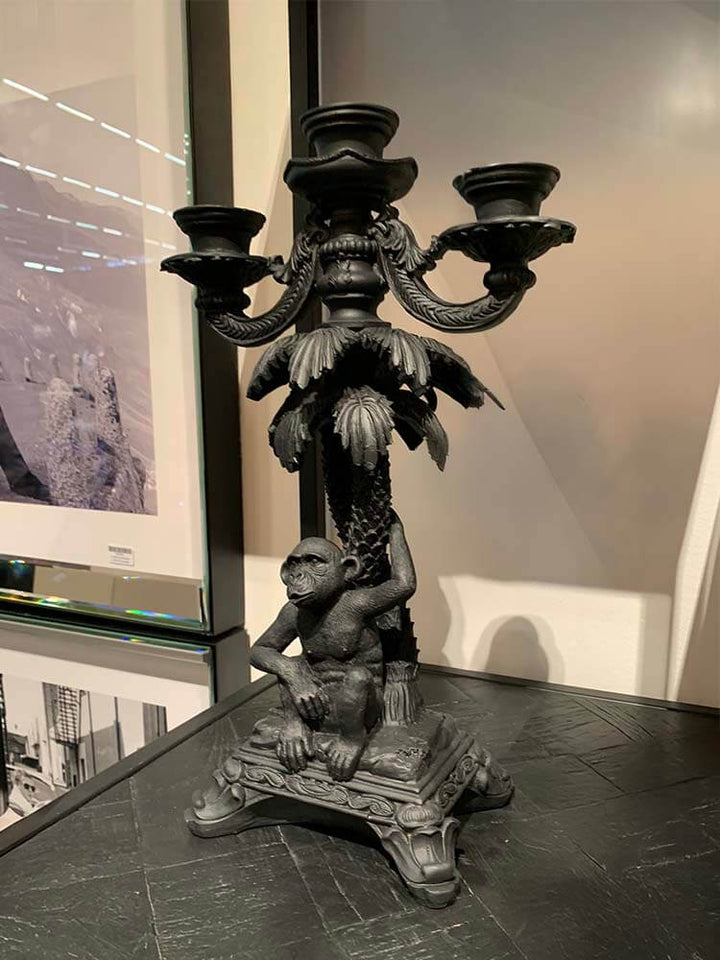 Decorative candle holders featuring a black monkey holding a palm tree 