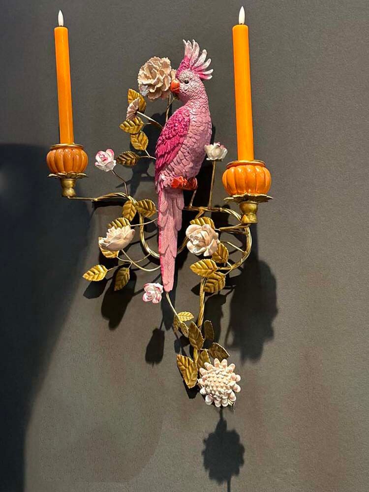 Decorative wall sconce with a pink parrot and floral design 