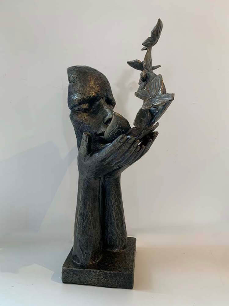 Bronze sculpture of a figure holding  butterflies 