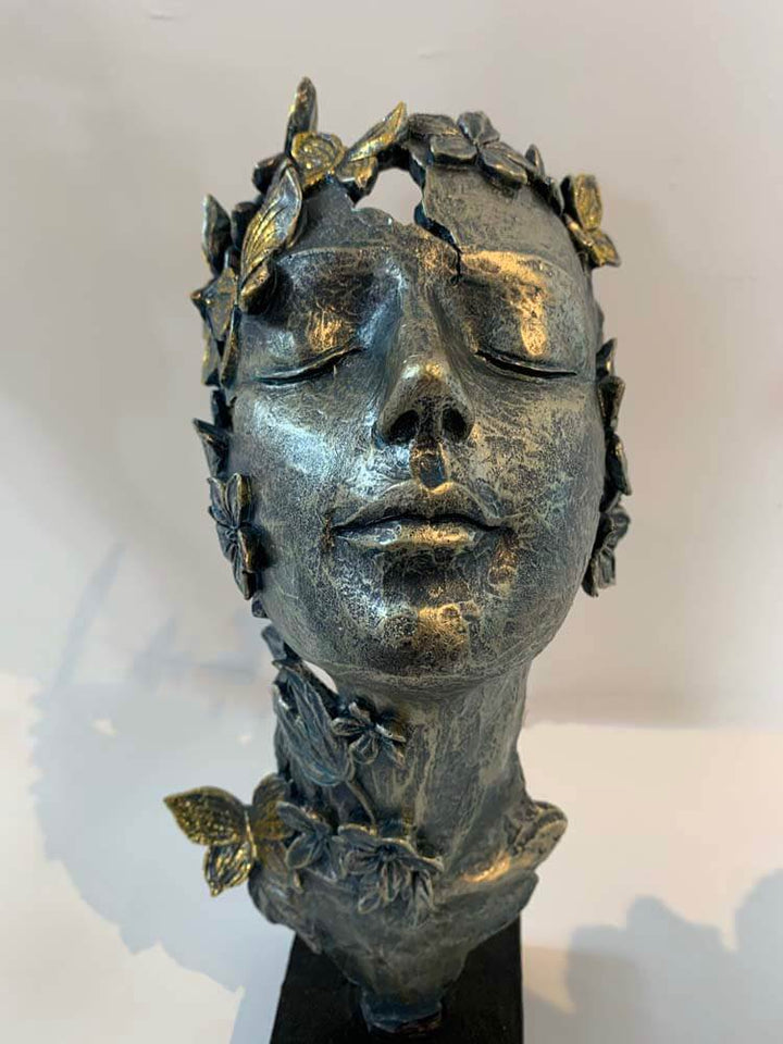 Female faces with butterflies on  face sculptures gold