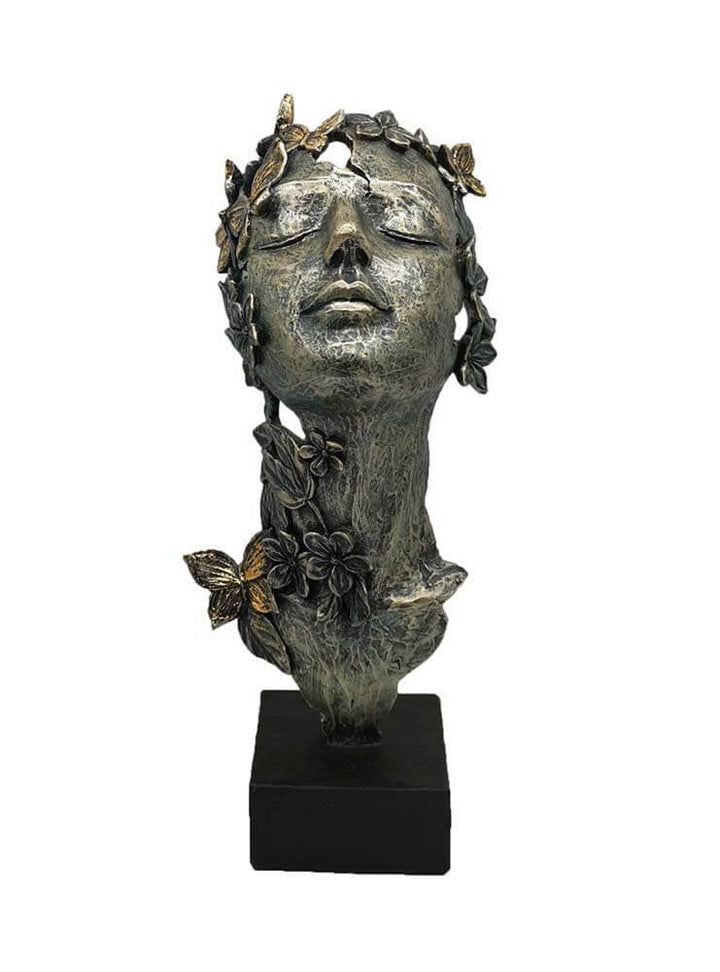Bronze sculpture of a woman's head with floral and butterfly details 