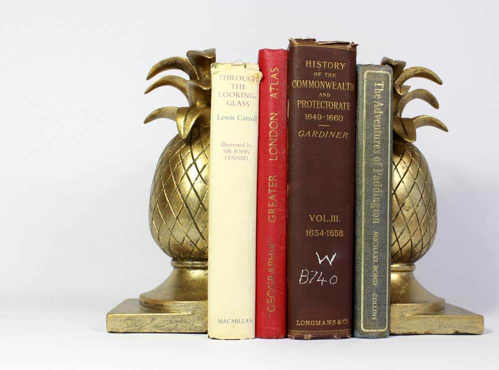 Gold pineapple bookends holding books, The Dutch Hospital United Kingdom