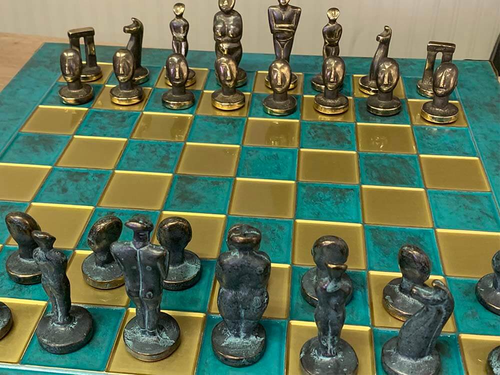 Chessboard with decorative chess pieces on a checkered turquoise blue and gold surface