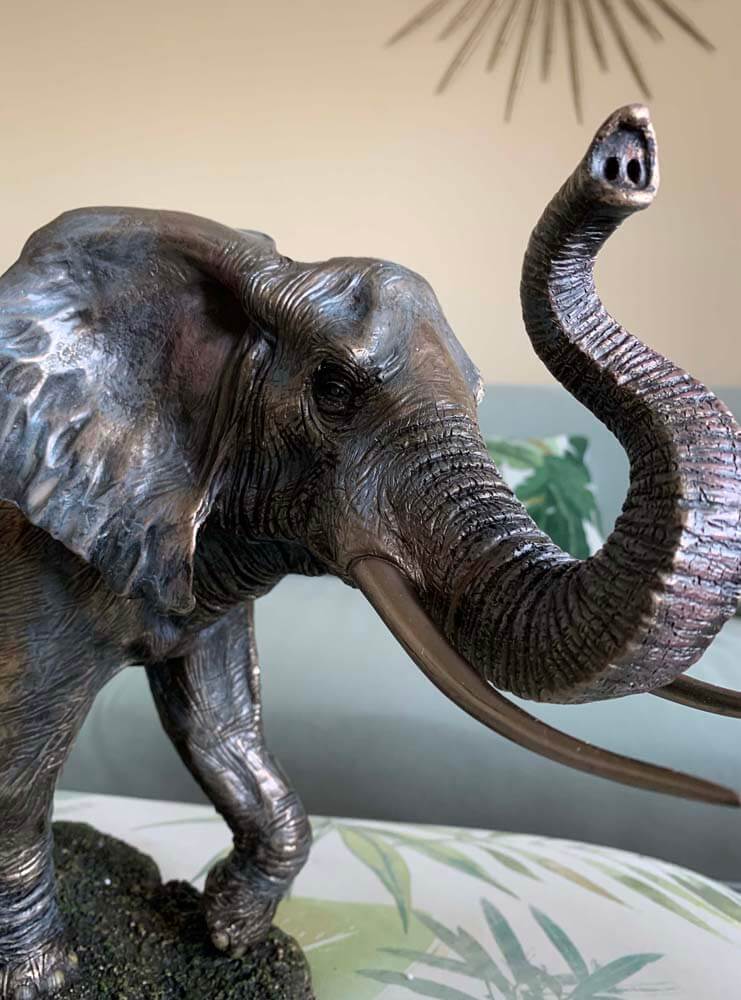 Bronze elephant sculpture with raised trunk 