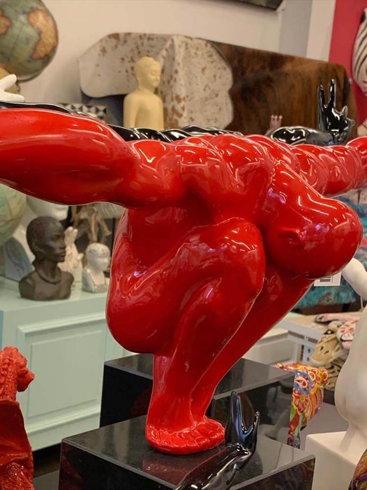 Red abstract sculpture Arm outstretching male 