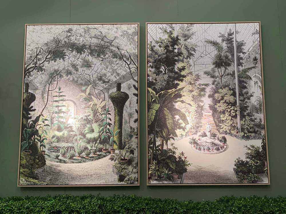 Framed wall art featuring a tropical garden with palm trees.