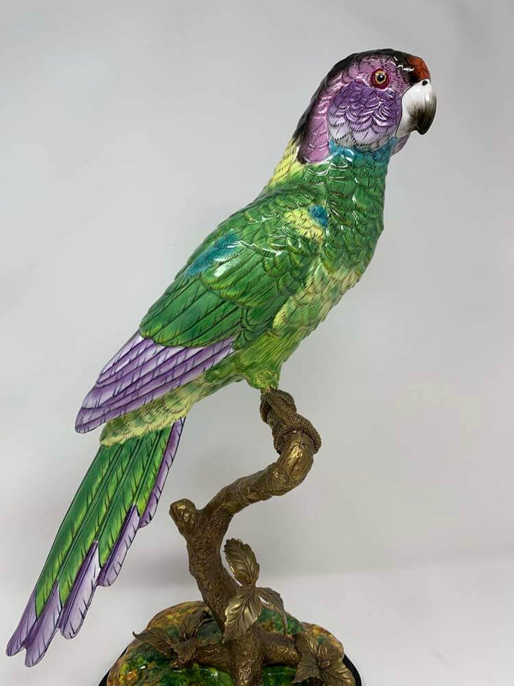 Colourful green parrot figurine on a branch ceramic and bronze