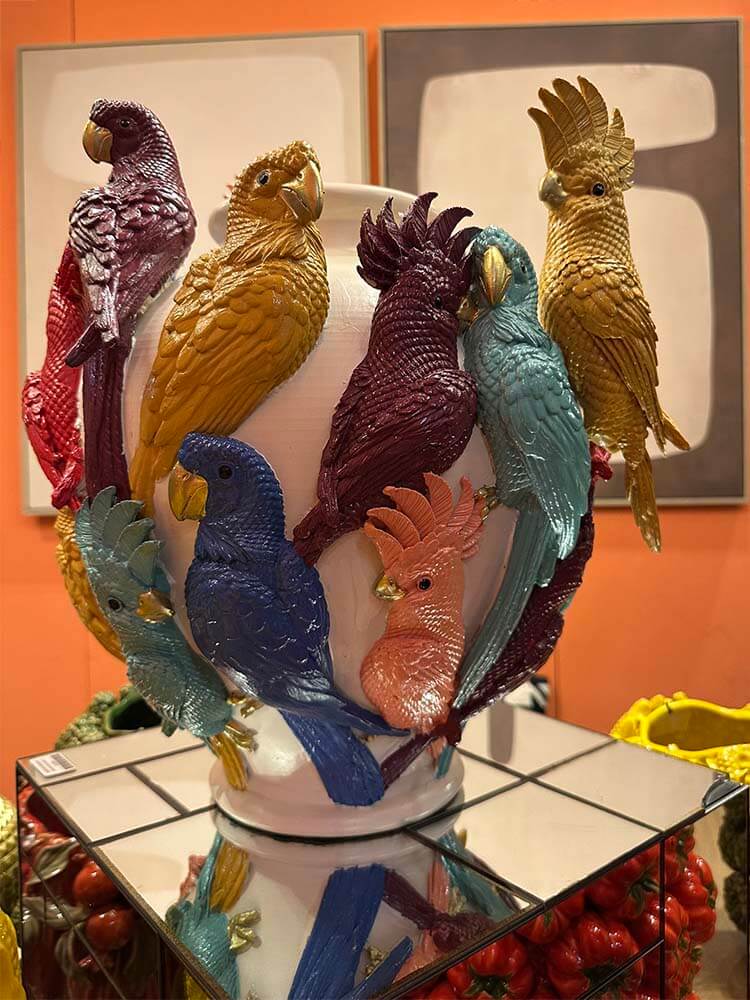 Colourful parrot figurines on a decorative flower vase