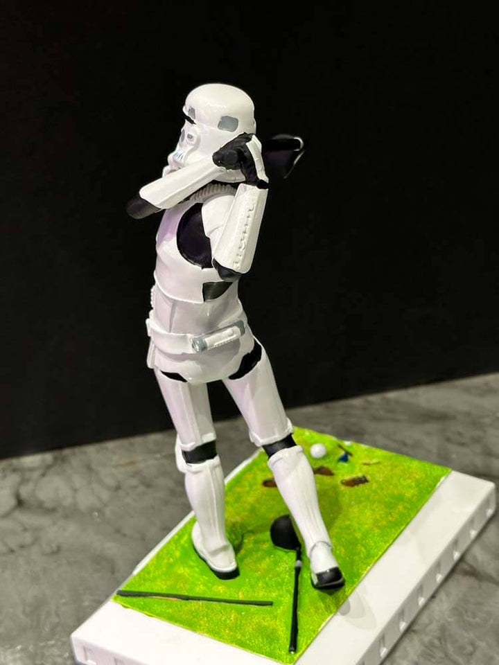 Stormtrooper figure in a golfing pose on a small green platform 
