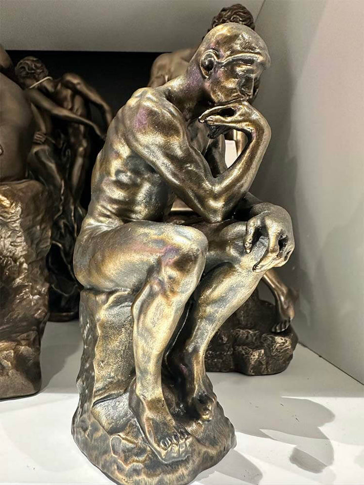 Bronze plated sculpture of The Thinker by Auguste Rodin, depicting a nude male figure in deep contemplation, museum-quality replica, iconic philosophical art, collectible bronze statue.