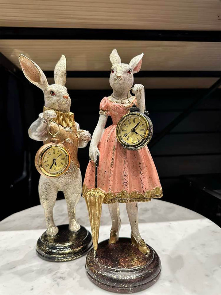 Antiqued Mrs Rabbit figurine with working pocket watch and umbrella, in pink with gold details adding whimsical charm.